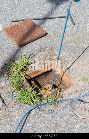 Geologo tenendo inclinometro letture su strada, la misura della stabilità della pendenza. Foto Stock