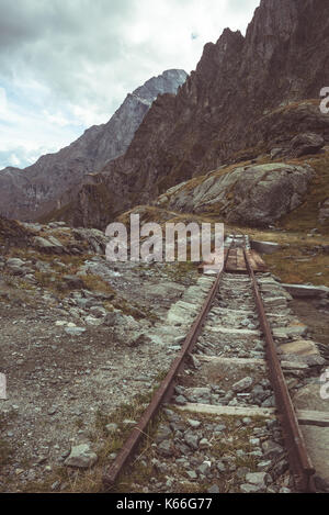 Vecchio e danneggiato ferrovia via utilizzato nelle alpi italiane ad alta quota della costruzione della diga, materiale di trasporto o scopo di data mining. Immagine tonico, vi Foto Stock