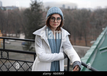 Vento capelli di soggetti di razza caucasica donna che indossa un cappello e sciarpa Foto Stock