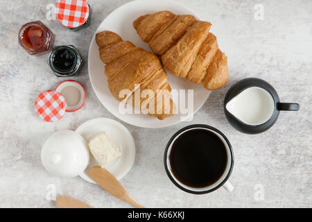 I croissant sulla piastra con caffè e marmellata Foto Stock