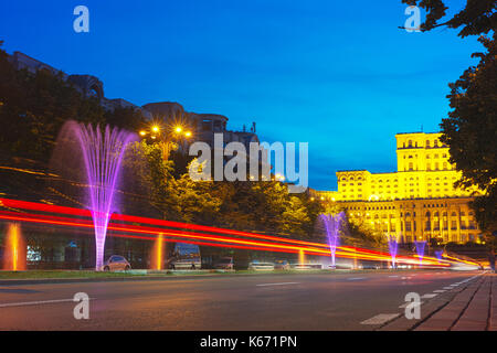 Liberty boulevard al crepuscolo con fontane illuminate guardando verso il palazzo del parlamento, il più amato e più odiato edificio in Romania. Foto Stock