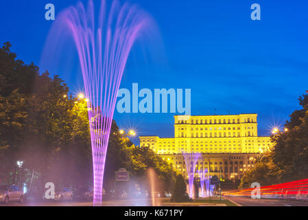 Liberty boulevard al crepuscolo con fontane illuminate guardando verso il palazzo del parlamento, il più amato e più odiato edificio in Romania. Foto Stock