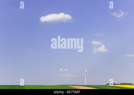 Wind Farm con la filatura turbina eolica nel mezzo di terreni agricoli di intensa produzione di raccolto. sostenibile e fonti di energia rinnovabile di produzione, ecologia e en Foto Stock