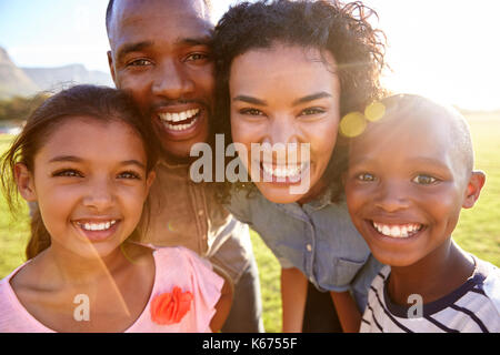 Ridendo famiglia nero all'aperto, vicino, back lit ritratto Foto Stock