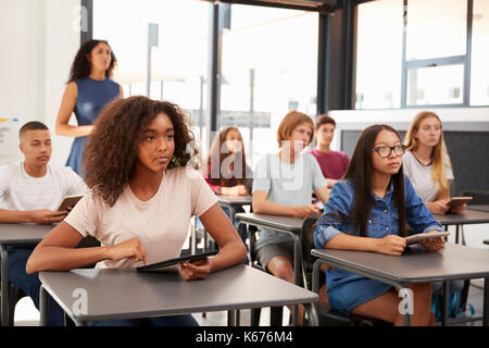 Insegnante si erge sul retro della sua scuola di alta classe Foto Stock