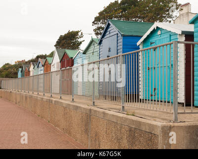 Una bella anche fila di cabine sulla spiaggia, con recinto di fronte all'dovercourt harwich; Inghilterra; Regno Unito Foto Stock