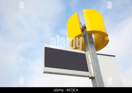 Un vuoto segno nero pronto per il testo con un giallo rotondo spazio vuoto anche contro il cielo blu Foto Stock