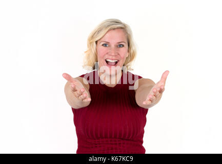 Una donna bionda che sorride con le braccia aperte in un accoglienza, invitando l'espressione Foto Stock