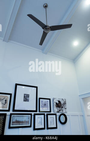 Una parete di immagini e un moderno ventilatore a soffitto. Foto Stock