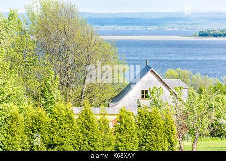 Paesaggio urbano in vista del paesaggio in Ile D'Orleans, Quebec, Canada con case, fiume San Lorenzo e colline Foto Stock