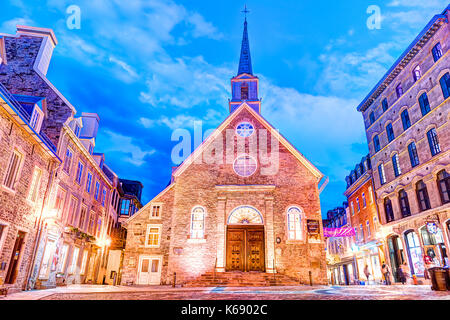 La città di Quebec, Canada - 31 Maggio 2017: Inferiore città vecchia strada a La Place Royale al crepuscolo, di notte o al crepuscolo con la cattedrale di Notre-dame-des-vittorie chiesa e peopl Foto Stock