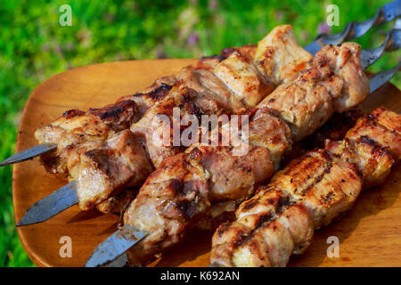 Primo piano di alcuni spiedini di carne alla griglia essendo in un barbecue Foto Stock