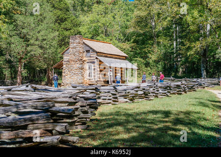 Turisti e visita a piedi attraverso john Oliver's cabin in Cades Cove Tennessee, USA, un popolare luogo di vacanza in Great Smoky mountains. Foto Stock