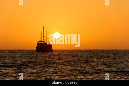 Ocean sunset nave silhouette è una vecchia nave di legno seduta in mare guardando il tramonto sull'oceano orizzonte. Foto Stock