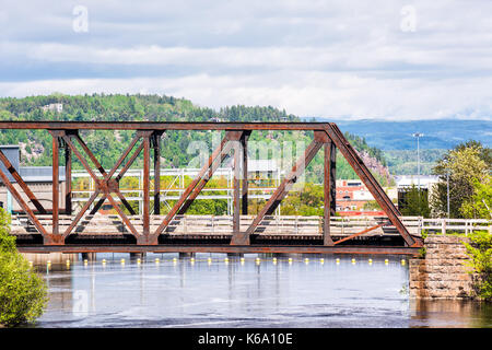 Saguenay, Canada - 3 Giugno 2017: Cityscape o skyline della città in Quebec con Chicoutimi fiume e l'acqua che scorre in estate con rusty ponte coperto in Foto Stock