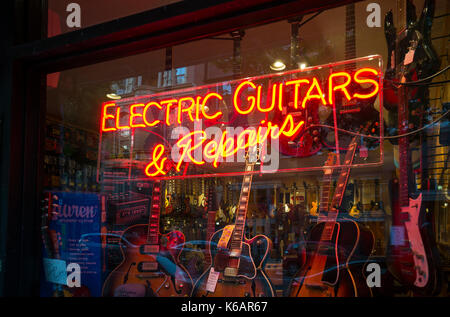 Chitarre elettriche e riparazioni insegna al neon nella finestra archivio Foto Stock