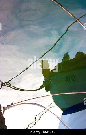 Sfocata la riflessione di una barca allacciare alla riva del mare capovolto; Foto Stock