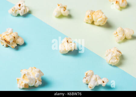 Il popcorn nel bicchiere di carta sul verde e blu. Foto Stock