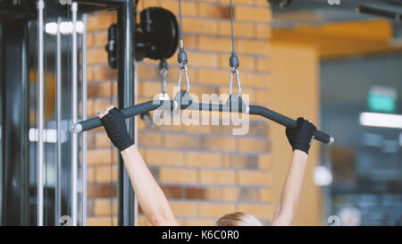 Fitness-club - la donna svolge esercizi per le mani in palestra Foto Stock