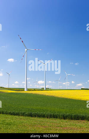 Wind Farm con la filatura turbine eoliche nel mezzo di terreni agricoli di coltura intensiva produzione sostenibile e le fonti rinnovabili per la produzione di energia e di ecologia e e Foto Stock