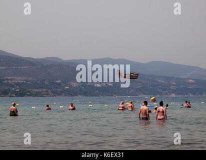 Sopra la spiaggia in alykanas un piano entra in per la raccolta di acqua per spegnere incendi nelle colline Foto Stock