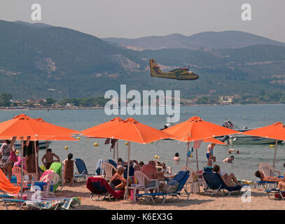 Sopra la spiaggia in alykanas un piano entra in per la raccolta di acqua per spegnere incendi nelle colline Foto Stock