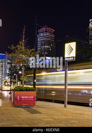 Media City, Salford Quays, Manchester - 9 settembre 2017, metrolink tram passano attraverso media city di notte Foto Stock