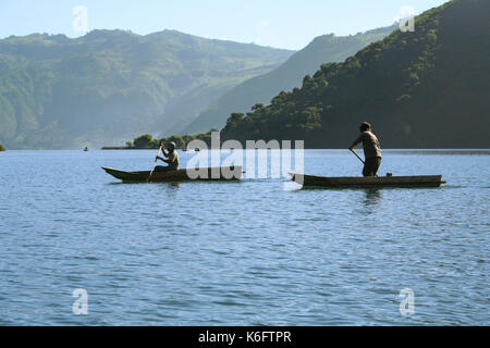 Due uomini in canoa kayak su un avventura di pesca sul lago atitln, guatemala Foto Stock