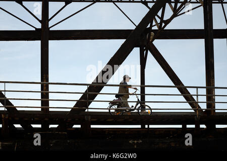 Uomo & bicicletta che attraversa ferro-incorniciato o ponte di ferro su canale a Sète o Sete, Hérault, Languedoc-Roussillon, Francia Foto Stock