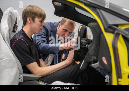 Il duca di cambridge consente di montare un airbag a una Mclaren auto con apprendista di anno nominee, alex machin sul piano della fabbrica, durante una visita alla mclaren del centro di produzione di Woking, Surrey. Foto Stock