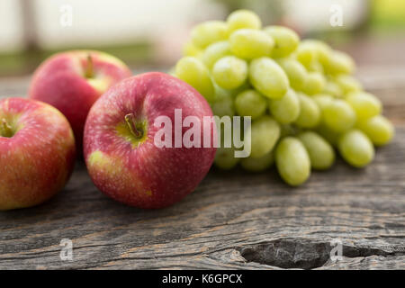 Primo piano di un tavolo d'annata con mele in primo piano e uvetta sullo sfondo. Decorazione di una vita semplice all'aperto. Foto Stock