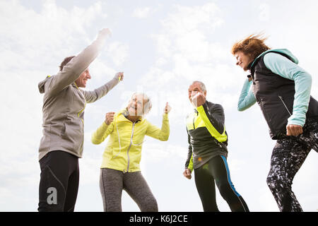 Guide senior all'aperto, appoggiando le mani in aria. Foto Stock