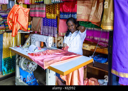 Kandy, Sri lanka - agosto 18, 2017: una sarta al lavoro nel suo negozio di Kandy mercato centrale Foto Stock