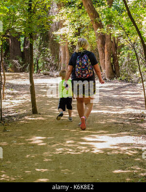 Una mezza età donna caucasica prende un piccolo ragazzo su una natura escursione nel Parco Martin Centro di Natura sMemorial road, Oklahoma City, Oklahoma, Stati Uniti d'America. Foto Stock