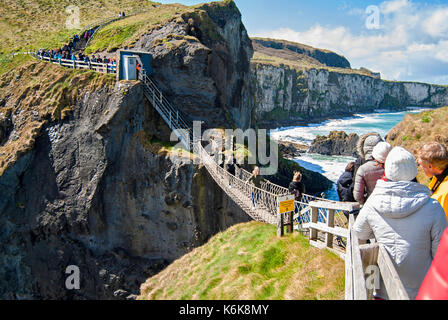 Ballintoy, Regno Unito - 2 maggio 2016: Carrick-a-Rede ponte di corde, una popolare destinazione turistica in Irlanda del Nord. turisti di passaggio il ponte. Foto Stock