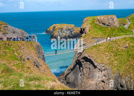 Ballintoy, Regno Unito - 2 maggio 2016: Carrick-a-Rede ponte di corde, una popolare destinazione turistica in Irlanda del Nord. turisti di passaggio il ponte. Foto Stock