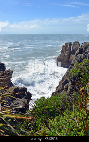 Grandi onde che si infrangono sulle rocce di Punakaiki, guardando verso nord la costa occidentale verso Karamea, Nuova Zelanda Foto Stock