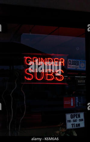 Smerigliatrice Neon subs signage contro un darkend vetrina. Foto Stock