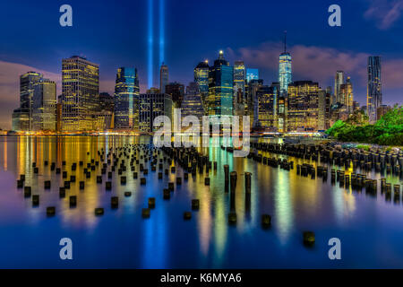 Settembre 11 Omaggio di NYC - due fasci di luce risplenda alta nel cielo blu in basso sullo skyline di Manhattan durante la 911 Omaggio di luci memorial. S Foto Stock
