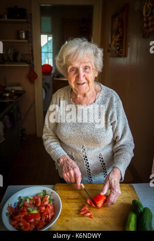 Donna anziana preparare verdure per insalata. Foto Stock