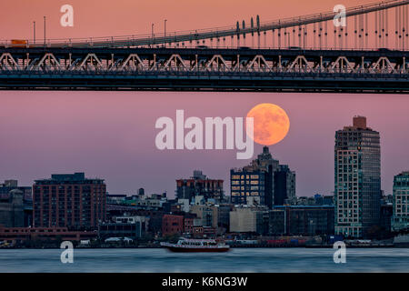 Super Moon Over Manhattan NYC - Una vista del Ponte di Manhattan con il super Moon Rising. Il supermoon era uno spettacolo tappo anche per un tour di acqua N Foto Stock