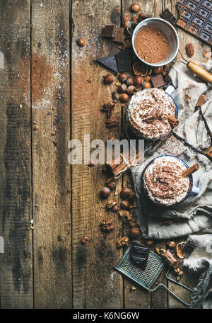 Cioccolata calda con panna montata, noci, spezie e cacao in polvere Foto Stock