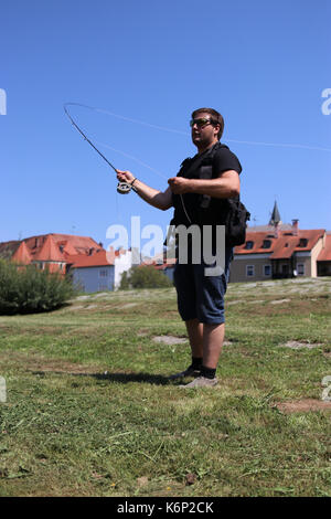 Giovane uomo con la canna da pesca pesca in un fiume in Baviera Foto Stock