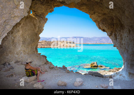 Incredibile vista estiva della donna in una grotta a koufonisi isola magica con acque turchesi, lagune, spiagge tropicali di pura sabbia bianca. Foto Stock