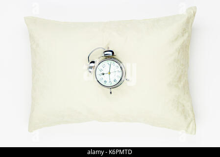 Retrò sveglia sul morbido cuscino in piuma di close-up su sfondo bianco Foto Stock