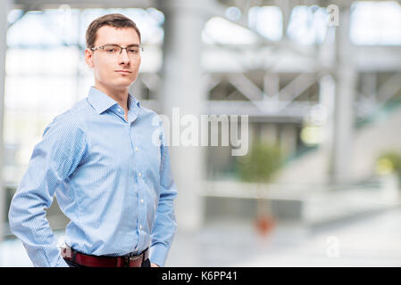 Maschio di successo con gli occhiali e la maglietta blu in office Foto Stock