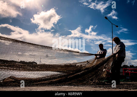 Killybegs, County Donegal, Irlanda. Xiii Sep, 2017. I pescatori in Irlanda il premier pesca porto approfittare di qualche raggio di sole per asciugare le reti da pesca sulla banchina dopo settimane di heavy rain e condizioni tempestose. Credito: Richard Wayman/Alamy Live News Foto Stock