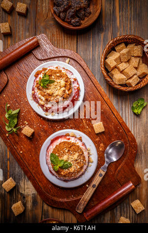 Cheesecake con salsa di fragole decorate con la menta Foto Stock