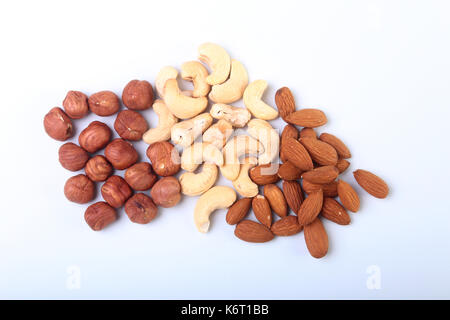 I dadi misti dalle nocciole, mandorle, anacardi isolati su sfondo bianco. Il fuoco selettivo. Foto Stock