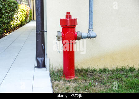 Vecchio rosso idrante di fuoco in strada. Fire hidrant per emergenza accesso antincendio Foto Stock
